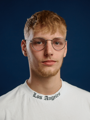 Junger Counter-Strike-2 Spieler mit blondem Haar und Mitglied des Esports Teams Xperion NXT, trägt Brille mit runden Gläsern und ein weites Shirt mit dem Aufdruck Los Angeles.