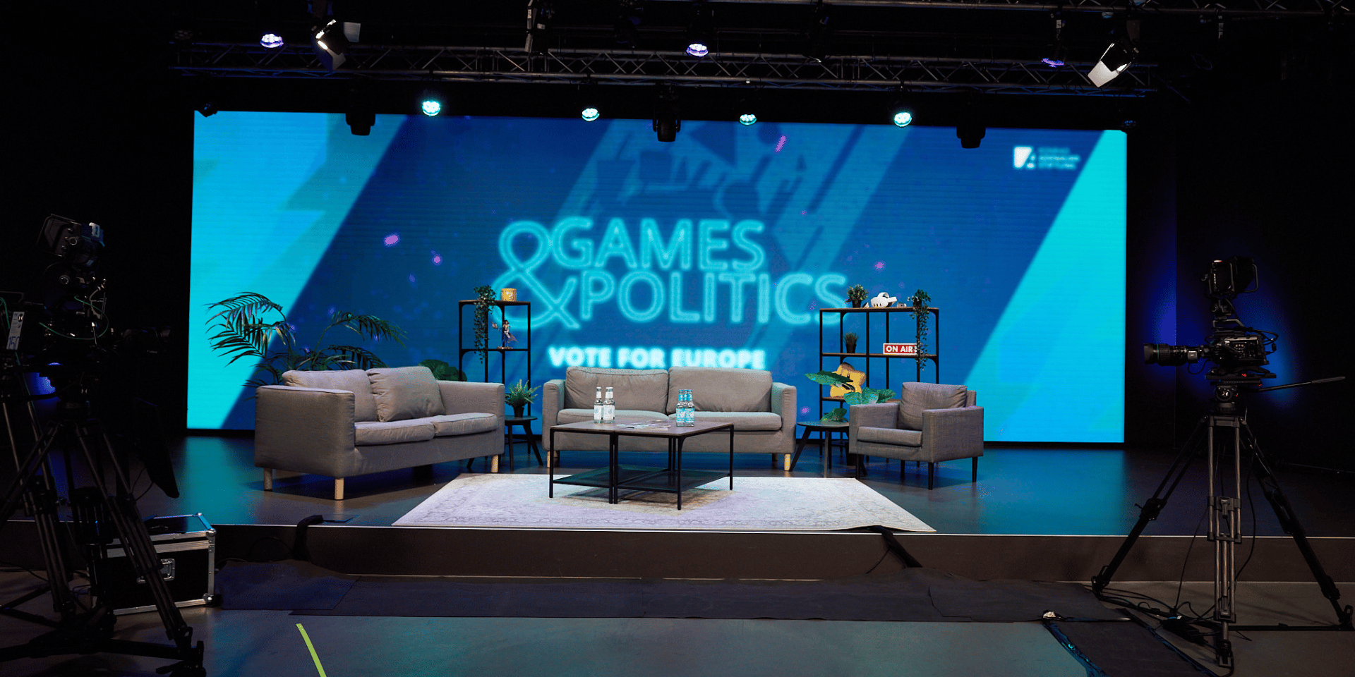 Games&Politics Bühne der Show Games&Politics, welche live auf Twitch ausgestrahlt wurde, mit der Unterüberschrift Vote for Europe. Es stehen 5 Sessel auf der Bühne und im Hintergrund ist das Games&Politics Vote for Europe Logo samt Schriftzug auf einem LED Screen zu sehen.