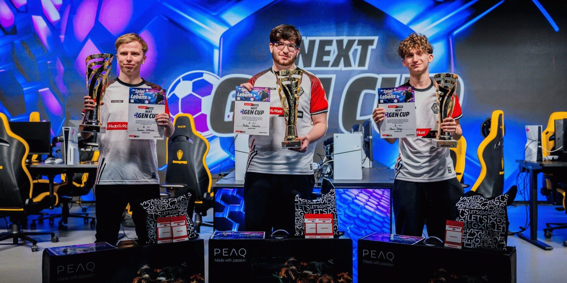 XPERION NXT STIPENDIUM Die Gewinner des XPERION NXT Stipendium halten ihre Pokale welche sich nun am Ende des MediaMarktSaturn Next Gen Cups gewonnen haben in die Höhe. Die jungen EA FC Esports Talente tragen bereits die Trikots und stehen im XPERION Hamburg.